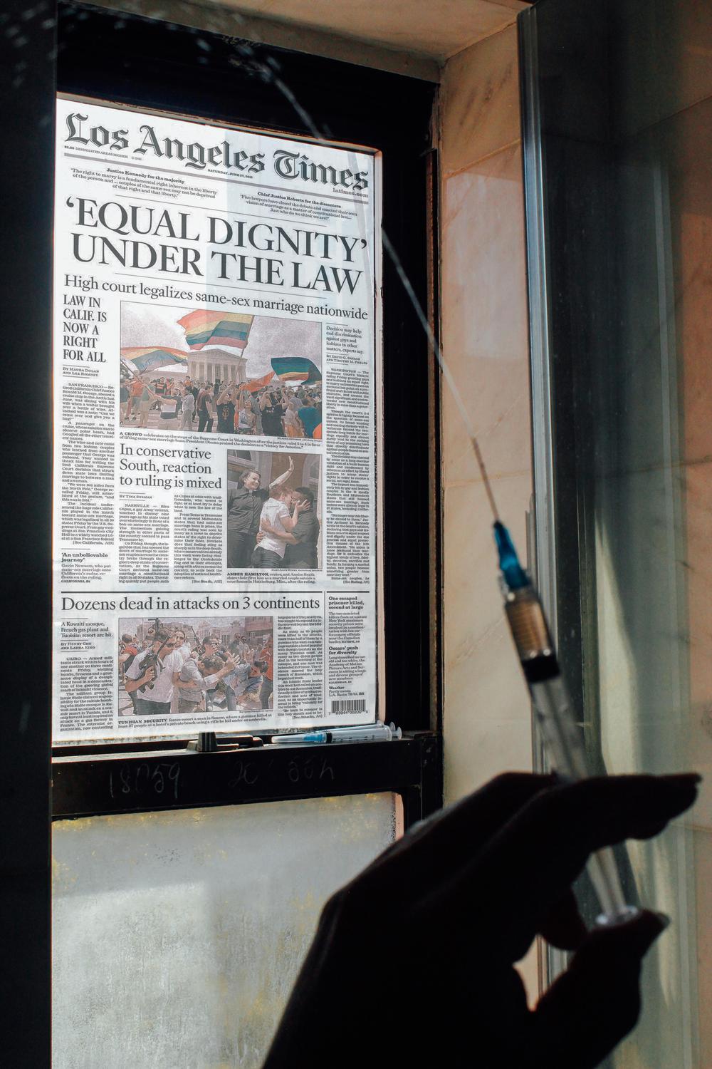 L.A. Times cover with headline for Equality Dignity Under the Law posted in a window with a person